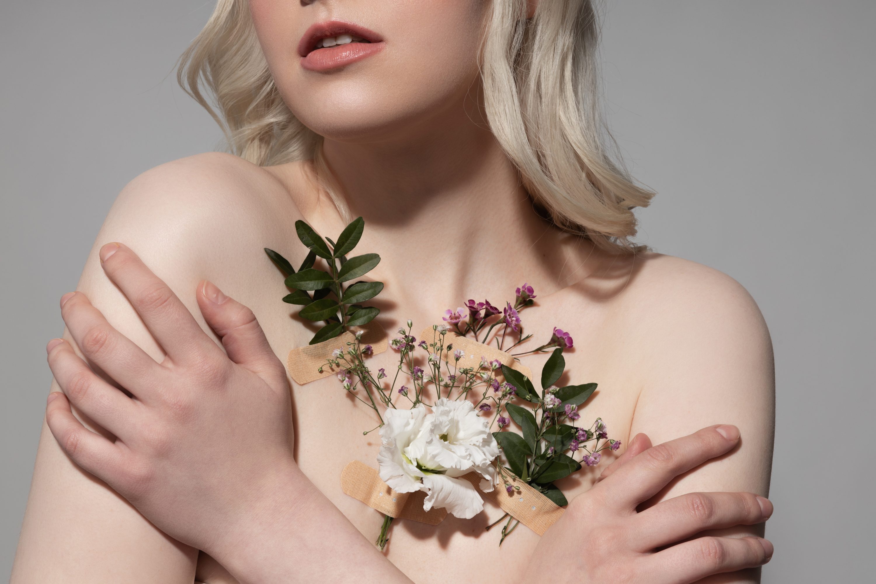 Band Aids hold flowers over a woman's heart.